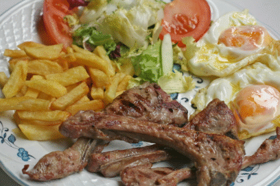 Chuletas de cordero con ensalada y patatas fritas